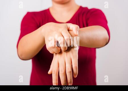 Die schöne asiatische Frau, die mit Copy-Space, Medical and Healthcare Concept ihren juckenden Arm auf weißem Hintergrund kratzt Stockfoto