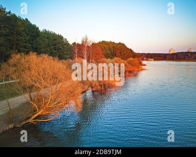Am See mit bunten Bäumen im Frühling Sonnenlicht. Der Aprilabend am See neben Minsk, Weißrussland. Erholungszone aus der Luft. Wunderschöne Sonnenuntergangsszene. Stockfoto