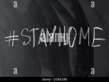 Inschrift Bleib in Kreide mit Hashtag auf einer schwarzen Kreidetafel zu Hause, Konzept der Selbstisolierung in einer Epidemie und Pandemie Stockfoto