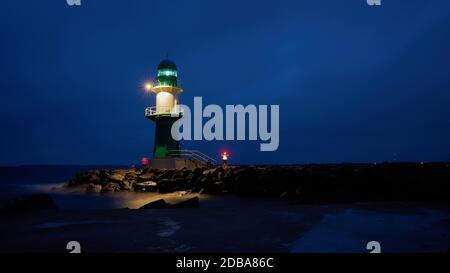 Der Leuchtturm Molenfeuer an der Westpier an der Küste von Warnemünde in Deutschland Stockfoto