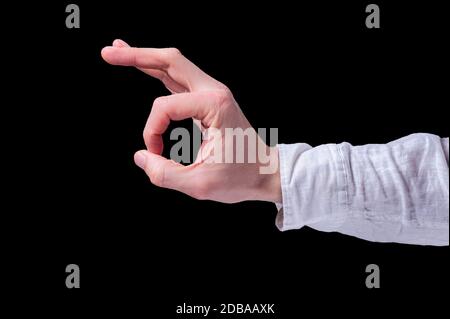 Die menschliche Hand in einem weißen Hemd zeigt das OK- oder Ringgestenzeichen auf isoliertem schwarzem Hintergrund Stockfoto