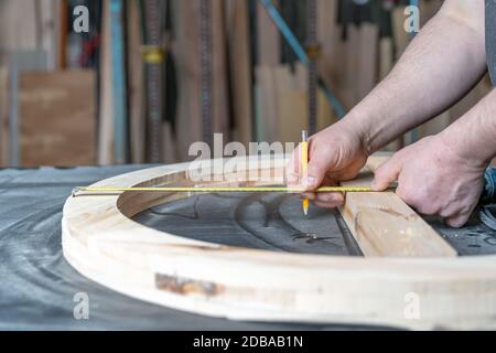 Messung und Planung in Schreinerei für die Herstellung von runden Holzfenstern. Stockfoto