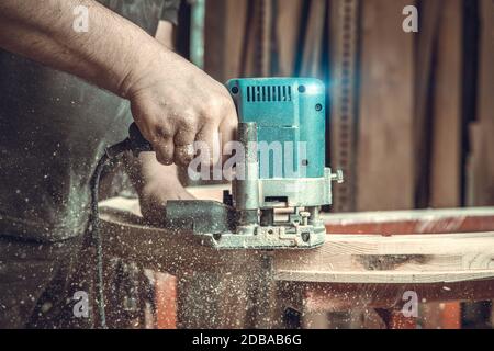 Holzfräsen mit elektrischen Fräser in Tischlerei. Farbtonierung Stockfoto