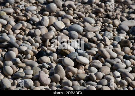 Große, kleine, runde Steine am Mittelmeer in der Provinz Alicante, Spanien Stockfoto