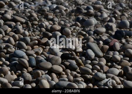 Große, kleine, runde Steine am Mittelmeer in der Provinz Alicante, Spanien Stockfoto