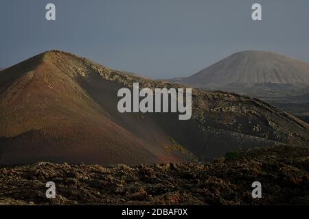 Schöne Vulkanlandschaft am frühen Morgen in Lanzarote, Kanarische Inseln, Spanien. Die calima Wind macht ein surreales Licht. Stockfoto