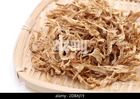 chinesische Medizin, getrocknete Pflanzen in einem Bambuskorb auf weißem Hintergrund. Stockfoto