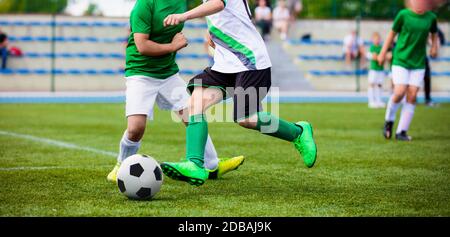 Fußball-Spieler Laufen. Sportwettkampf Zwischen Jugend-FuSsballmannschaften. Young Boys im harten Duell mit dem Fußballspiel. Juniorfußballer Kickend Stockfoto