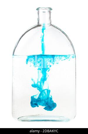Blaue Tinte löst sich in Wasser in Glasflasche auf weißem Hintergrund isoliert Stockfoto