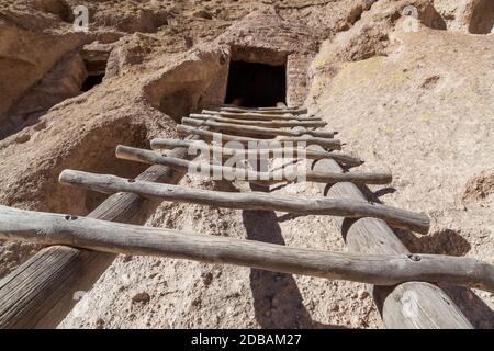 Eine Holzleiter führt zu einer geschnitzten Höhlenöffnung In eine Sandsteinklippe von den Pueblo-Leuten in Frijoles Canyon in Bandelier National Monumen Stockfoto