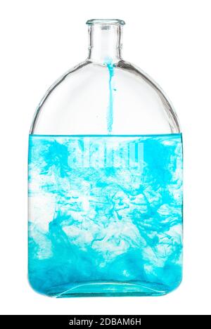 Blaues Aquarell löst sich in Wasser in der Flasche auf weißem Hintergrund isoliert Stockfoto