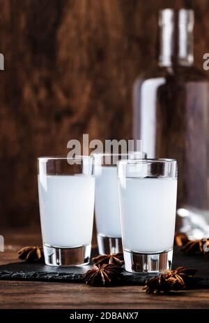 Ouzo - griechischer Anisschnaps, traditionelles starkes alkoholisches Getränk in Gläsern auf dem alten Holztisch, Platz für Text Stockfoto