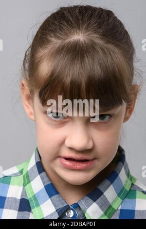 Porträt eines wütenden Grinsen zehn Jahre alten Mädchen von europäischem Aussehen, Nahaufnahme Stockfoto