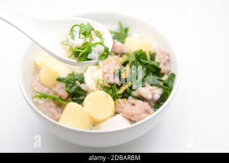 Gekochter Reis mit Schweinefleisch, Efeu-Kürbisblättern und weichem Tofu Stockfoto