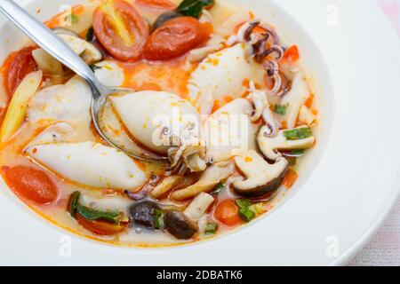 Kalmare und Zitronengras würzige Suppe mit Pilzen, Tomaten und Kräutern Stockfoto