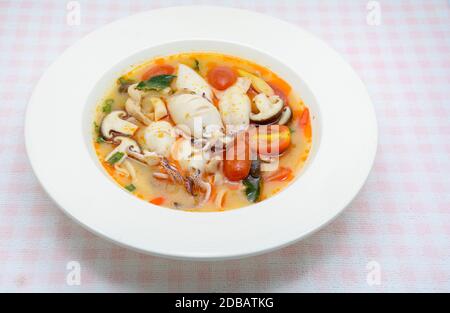 Kalmare und Zitronengras würzige Suppe mit Pilzen, Tomaten und Kräutern Stockfoto