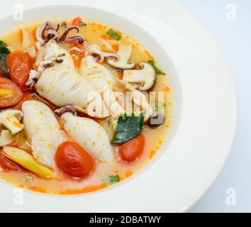 Kalmare und Zitronengras würzige Suppe mit Pilzen, Tomaten und Kräutern Stockfoto