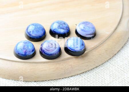 Galaxy trinken Erstellen Achterbahnen mit Harz, Glitter und Pigment Pulver, handgefertigte Produkte. Geeignet für Schlüsselbunde, Halskette und Anhänger. Stockfoto