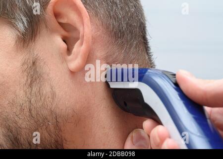 Friseur richtet Haar auf dem Hals eines Mannes Stockfoto