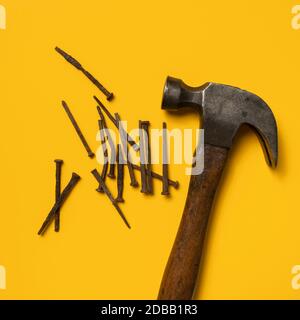 Vintage Nägel und Hammer auf gelbem Hintergrund Stockfoto