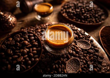 Espresso Shot und Kaffeebohnen, dunkler Hintergrund Stockfoto