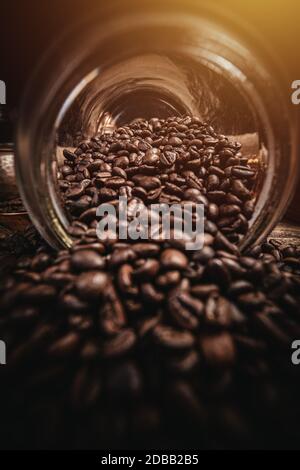 Braune Kaffeebohnen aus dem Glas verschüttet Stockfoto