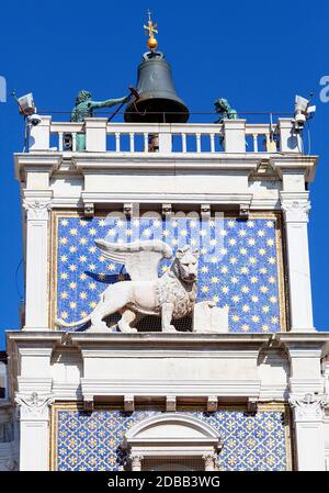 Markuhr-Turm auf dem Markusplatz, Löwenrelief auf der Fassade, Venedig, Italien. Der geflügelte Löwe von Venedig ist ein Symbol der Stadt. Stockfoto