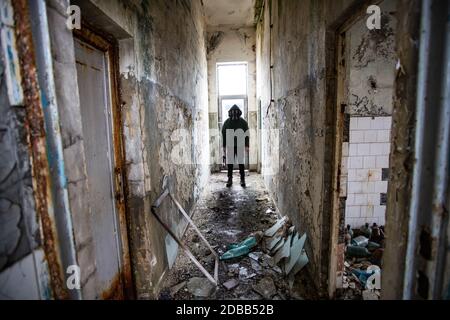 Postalyptischer Überlebender in Gasmaske in einem zerstörten Gebäude. Umweltkatastrophe, konzept von armageddon. Stockfoto