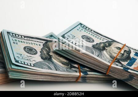 Isoliertes Bündel von Dollar. Ein großer Stapel von hundert-Dollar-Scheinen liegt diagonal über dem weißen Hintergrund des Bildes. Nahaufnahme. Kontrastreiche CO Stockfoto