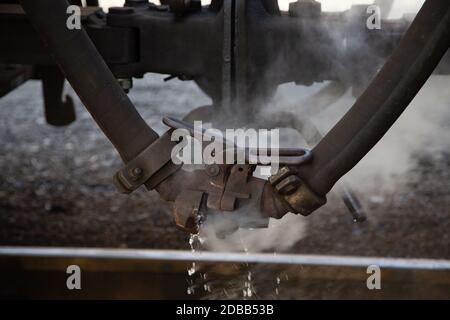 Aus einem Rohr einer alten Dampfeisenbahn kommt sehr heißer Dampf Stockfoto