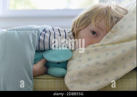 Junge (4-5) im Bett liegend Stockfoto