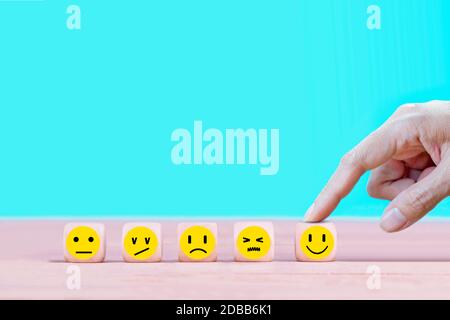 Geschäftsmann wählt eine glückliche Emoticon Icons Gesicht. Service, Kommunikationskonzept Stockfoto