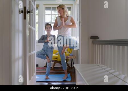 Mutter mit Tochter (6-7) praktiziert gemeinsam Yoga zu Hause Stockfoto