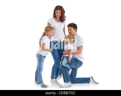 Freundliche Familie. Ehemann mit zwei Söhnen lächeln und umarmen schwangere Frau, isoliert auf einem weißen Hintergrund. Glückliche Eltern. Schwangere Mutter und f Stockfoto