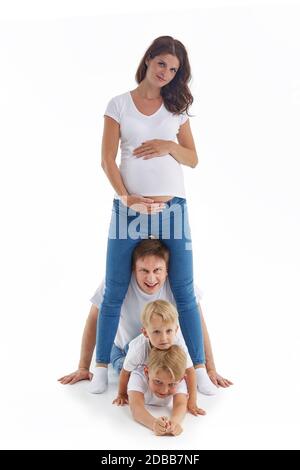 Freundliche Familie. Ehemann mit zwei Söhnen liegen in der Nähe schwangerer Mutter, isoliert auf weißem Hintergrund. Glückliche Eltern. Schwangere Mutter und Vater wit Stockfoto