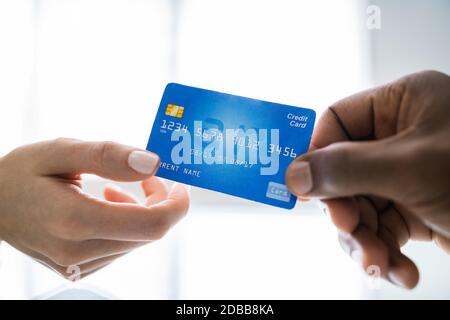 Nahaufnahme von zwei Geschäftsleuten, die eine Kreditkarte halten Stockfoto