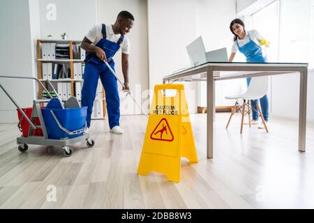 Junge männliche und weibliche Reiniger Reinigung Büro Stockfoto