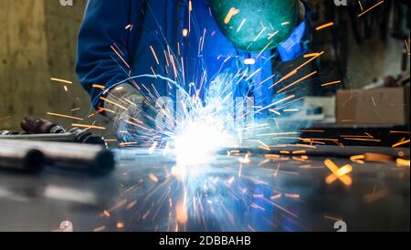 Schweißer in seiner Werkstatt Schweißen von Metall, viel um die Funken fliegen Stockfoto