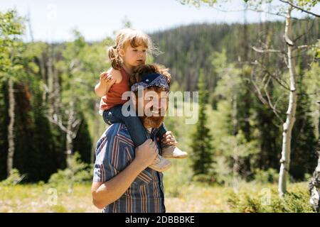 USA, Utah, Uinta National Park, Porträt eines lächelnden Mannes, der seine Tochter (2-3) auf den Schultern in der Landschaft trägt Stockfoto