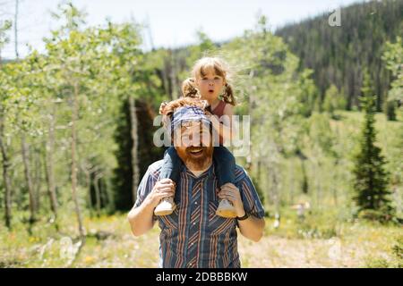 USA, Utah, Uinta National Park, Porträt eines lächelnden Mannes, der seine Tochter (2-3) auf den Schultern in der Landschaft trägt Stockfoto