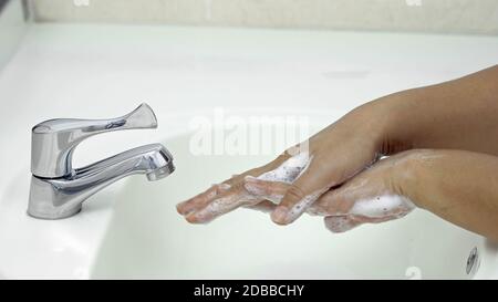 7 Schritte Händewaschen - Schritt 2/7 Rub den Rücken beider Hände, Schutz vor Coronavirus COVID-19 Infektion Stockfoto