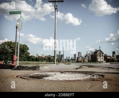 Distressed Detroit neihborhood mit vielen verlassenen Häusern. Downtown skysrapers im Hintergrund. Stockfoto