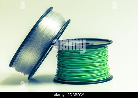 Filament für 3D Drucker kristallklar und leuchtend grün vor hellem Hintergrund. Stockfoto