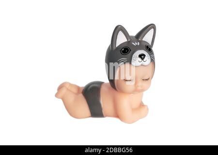 Niedliche kleine Puppe in einem Hundekostüm mit geschlossenen Augen. Liegt auf einem weißen isolierten Hintergrund. Ein entzückendes Spielzeug für ein Geschenk oder ein Kinderspiel. Weichfokus. Stockfoto