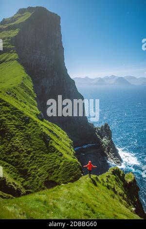 Dänemark, Färöer, Klaksvik, Trollanes, Frau, die auf einer Klippe steht und auf das Meer schaut Stockfoto