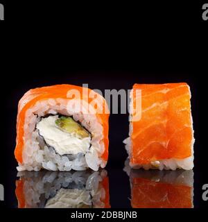 Zwei Stücke Sushi Nahaufnahme auf schwarzem Hintergrund. Makroaufnahme japanischer Küche. Stockfoto