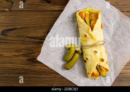 Köstliche türkische Döner Kebab auf Pita Brot mit rasiert geröstet Fleisch aus einer traditionellen vertikalen Rotisserie mit frischem Salat serviert Zutaten auf Rost Stockfoto