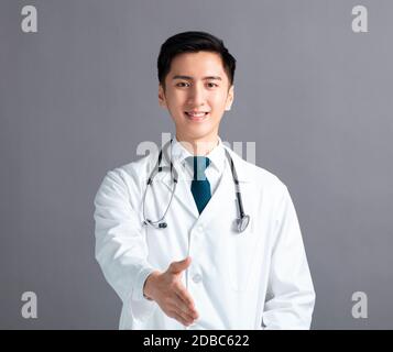 Portrait des männlichen asiatischen jungen Arztes mit Handshake-Geste Stockfoto