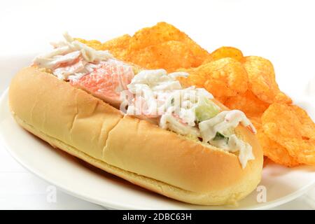 Ein Krabbensalat-Sandwich auf einem Brötchen mit Cheddar-Käse Kartoffelchips Stockfoto