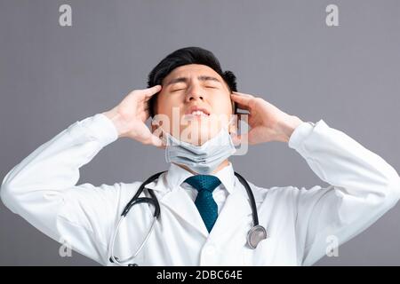 Stress und müde junge Ärzte tragen medizinische Maske Stockfoto